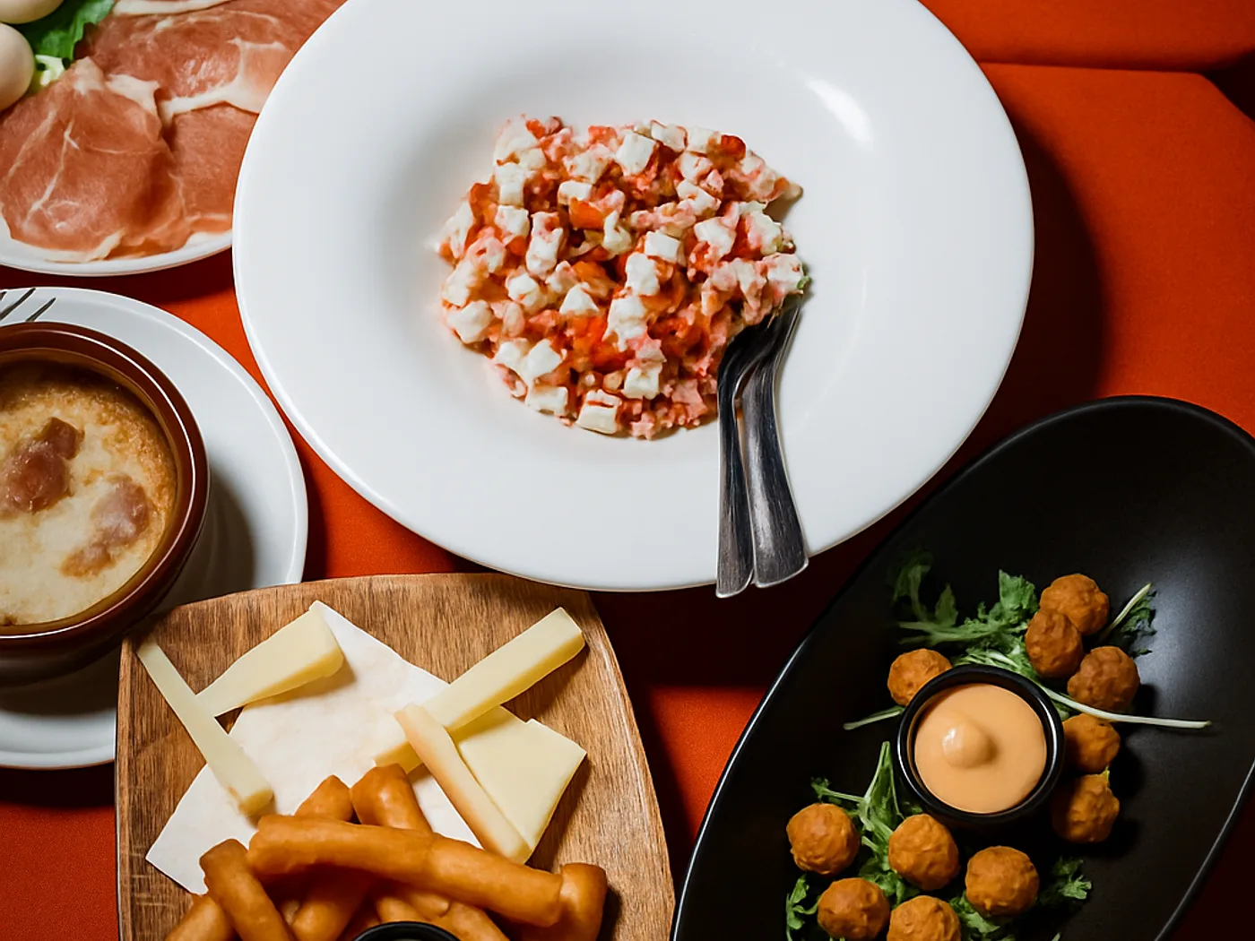 Selezione di antipasti della casa: polpette, sticks fritti e insalata di mare